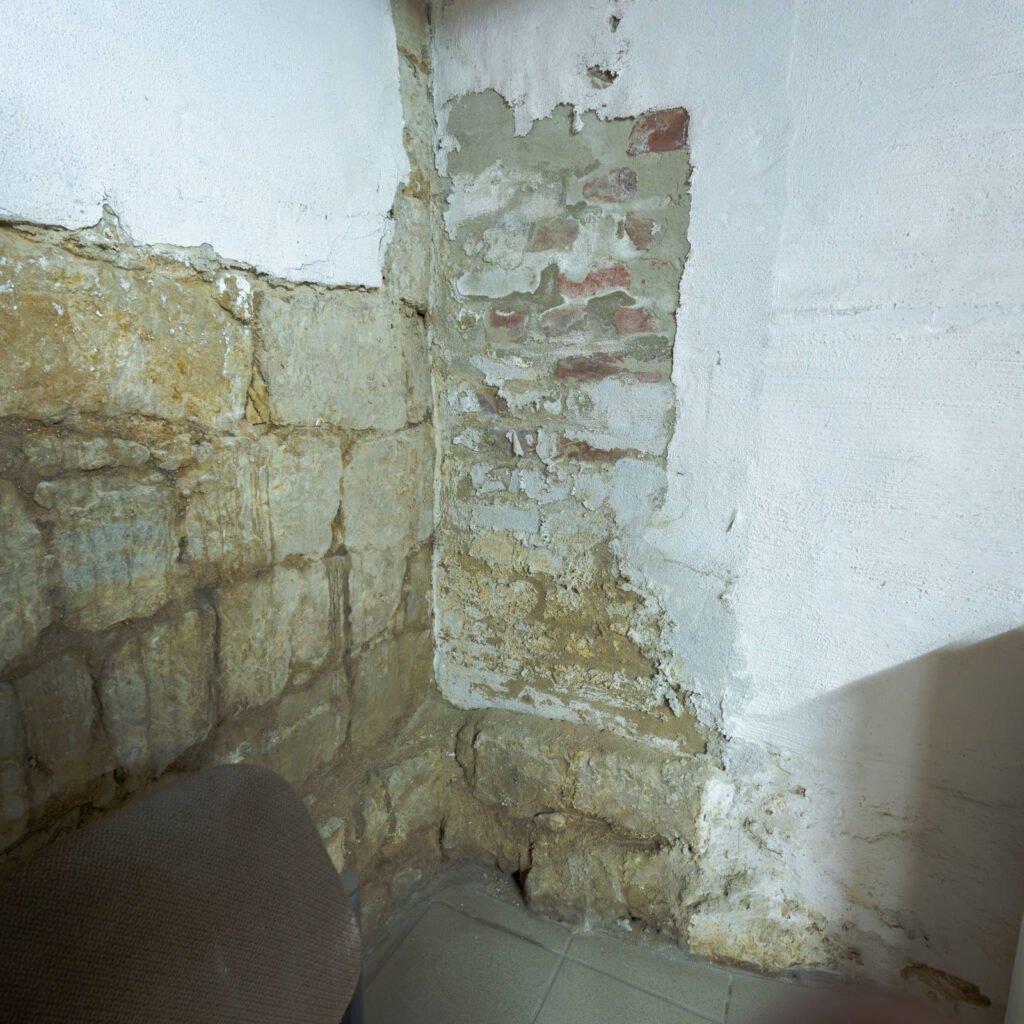 Durchfeuchtete Kellerwand aus Naturstein mit Salzausblühungen